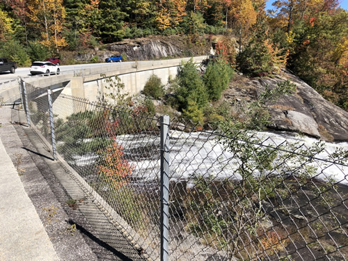 The bridge goes over the top of the water fall